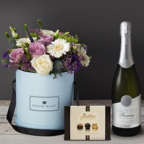 Bloom Magic - Flower Delivery Ireland - This beautiful flower arrangement contains many colourful flowers. It contains a mixture of purple and white roses, lisianthus, and gerbera. It is hand tied, and presented in either of our charcoal grey, or powder blue waterproof hat boxes. Flower Delivery in a hatbox is the perfect gift for any loved one. 