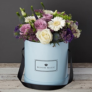 Bloom Magic - Flower Delivery Ireland - This beautiful flower arrangement contains many colourful flowers. It contains a mixture of purple and white roses, lisianthus, and gerbera. It is hand tied, and presented in either of our charcoal grey, or powder blue waterproof hat boxes. Flower Delivery in a hatbox is the perfect gift for any loved one. 
