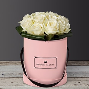 Une Nuit À Montmartre is an elegant bouquet of pure white avalanche roses. This arrangement of flowers is perfect for a romantic occasion or a birthday. This can be sent as a sympathy bouquet of flowers as well, and would look more subdued in a charcoal gray hatbox. 