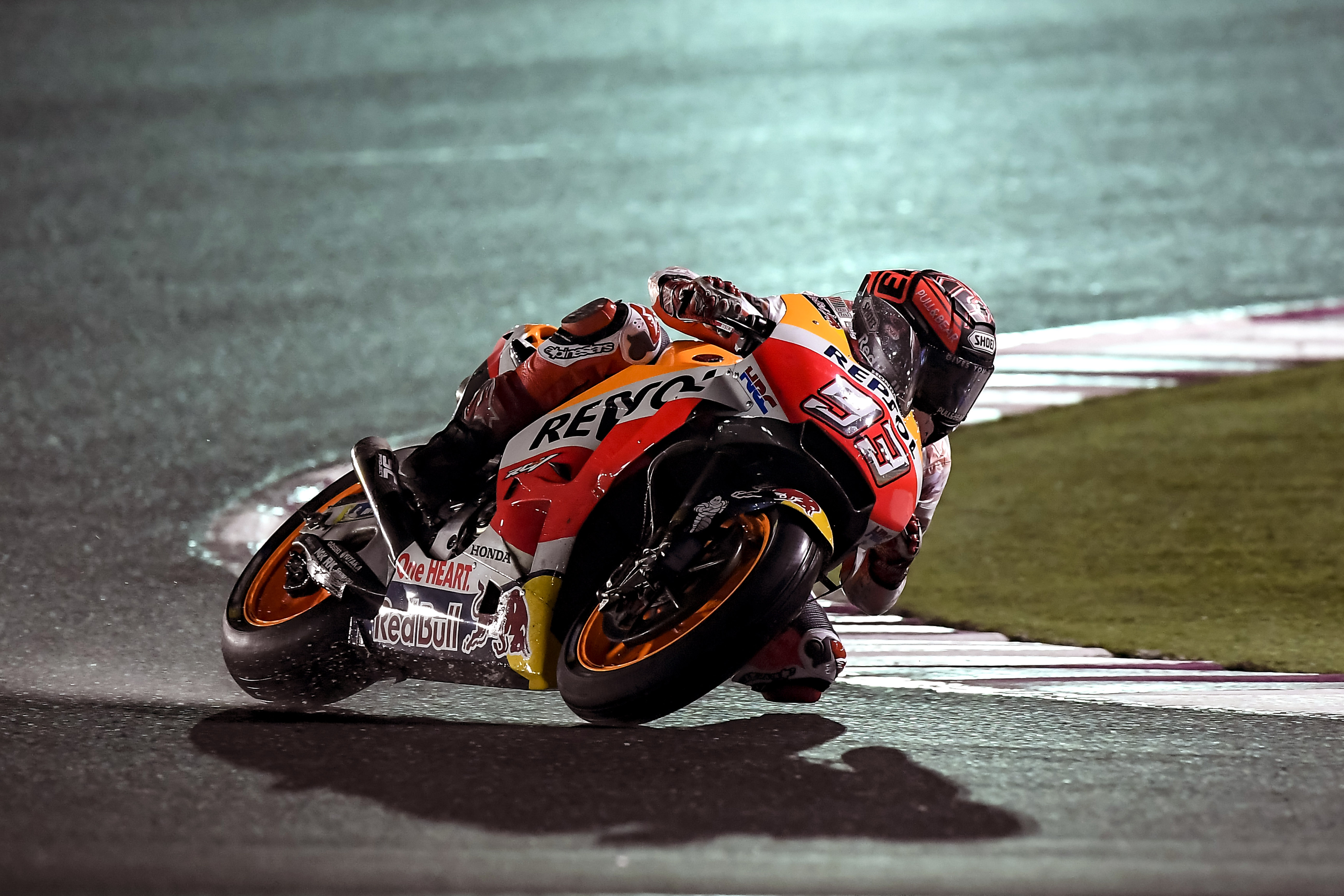 Marc Márquez tomando curva mientras su sombra se proyecta en el asfalto