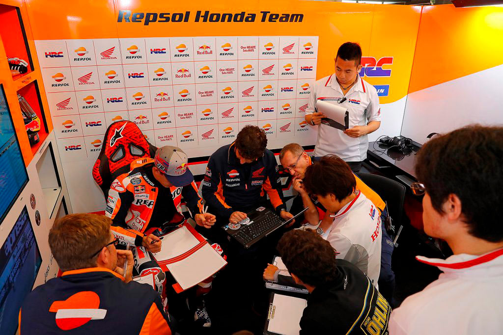 El equipo de Marc Márquez en el box tomando notas