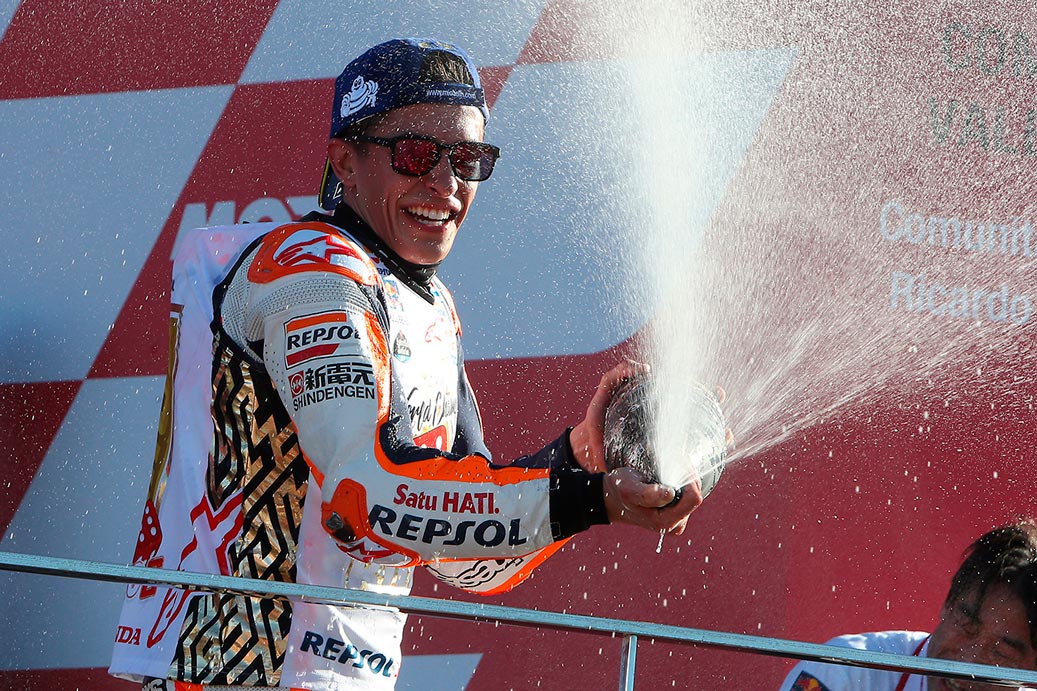 Marc Márquez celebra en el podio de Valencia su 6º Mundial Marc Márquez echando champán desde el podio
