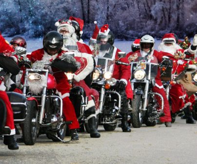 Papanoelada motera con muchos motoristas en cabalgata vestidos de Papa Noel