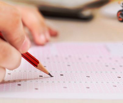 primer plano de la mana de un motero rellenando las casillas de un examen tipo test para sacarse el A2
