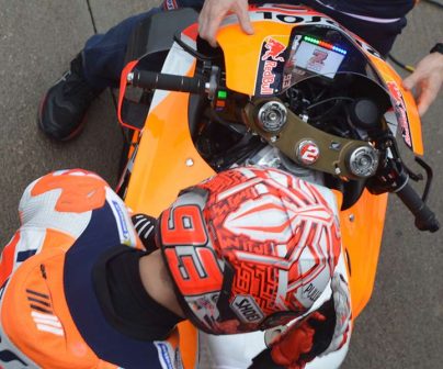 Marc Márquez junto a su moto con el dashboard celebrando el Mundial
