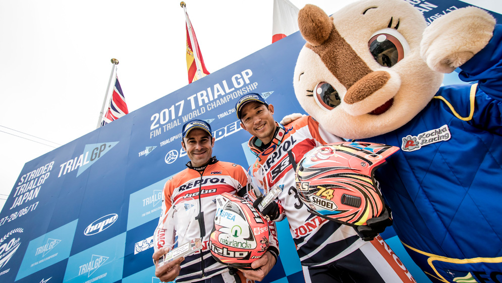 Toni Bou y Takahisa fujinami con Kochira en el podio de Motegi en 2017 TrialGP Toni Bou y Fujinami en podio con mascota de Motegi