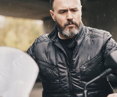 un motero curtido observa su moto antes de ponerse el casco