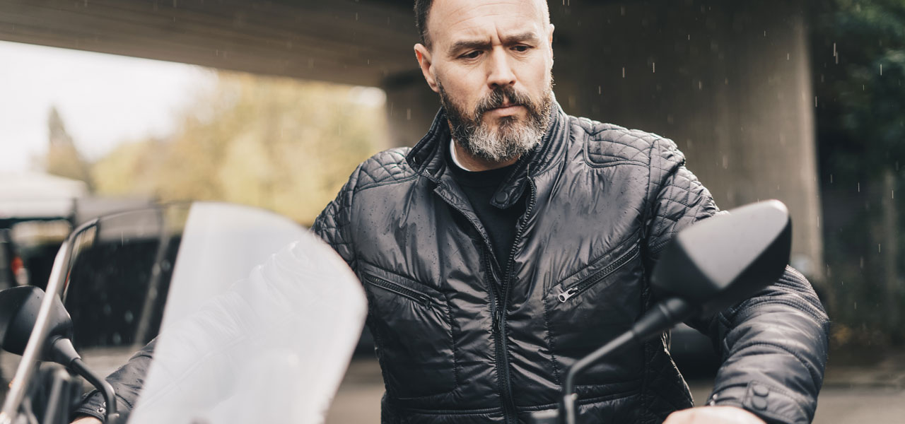 un motero curtido observa su moto antes de ponerse el casco un motero curtido observa su moto antes de ponerse el casco