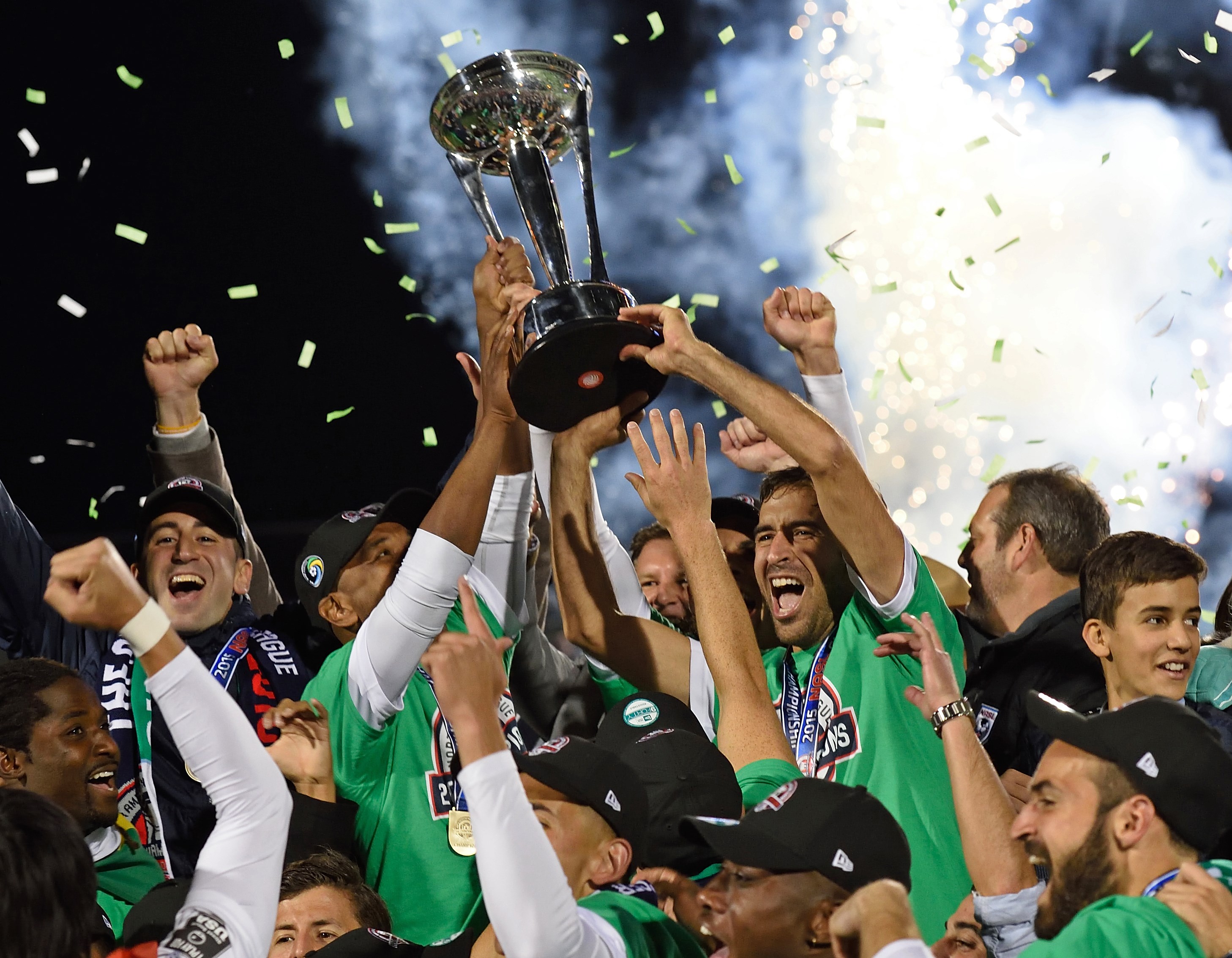 Spanish soccer star Raul (R holding trophy) celebrates with his teammates after the NASL Championship Final match between the NY Cosmos and the Ottawa Fury November 15, 2015 in Hempstead, NY. Raul has planned to retire after the match. AFP PHOTO/DON EMMERT (Photo credit should read DON EMMERT/AFP/Getty Images)