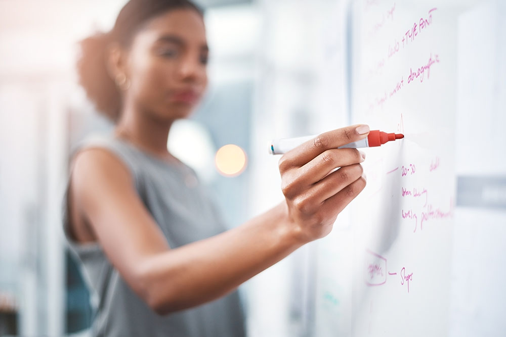 professional woman writing on a whiteboard