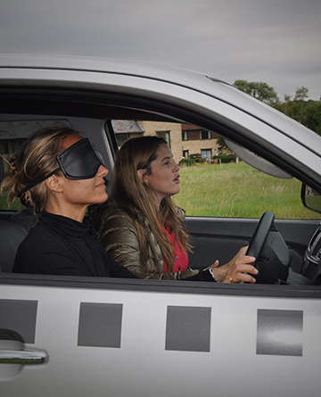 two girls blindfolded driving vehicle