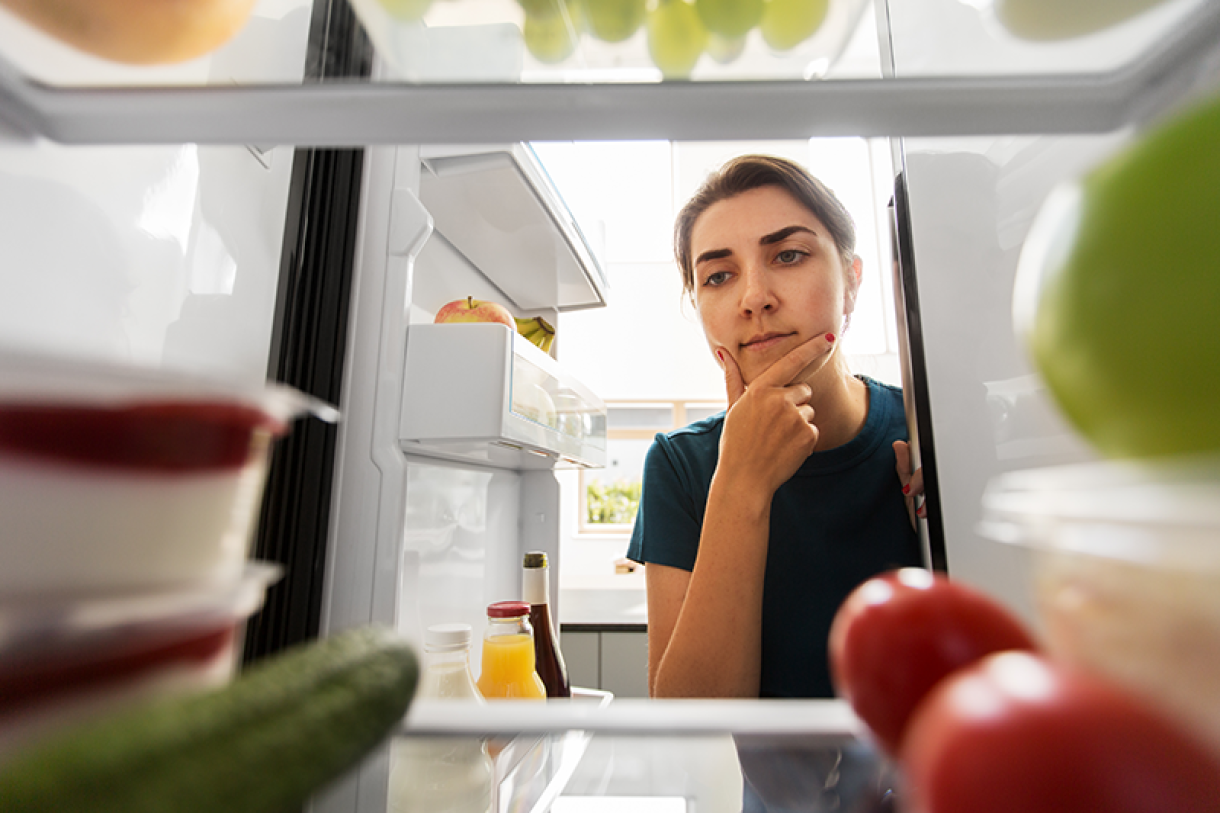 Thoughtful woman open fridge home kitchen