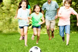 an image of children playing football outside on artificial grass