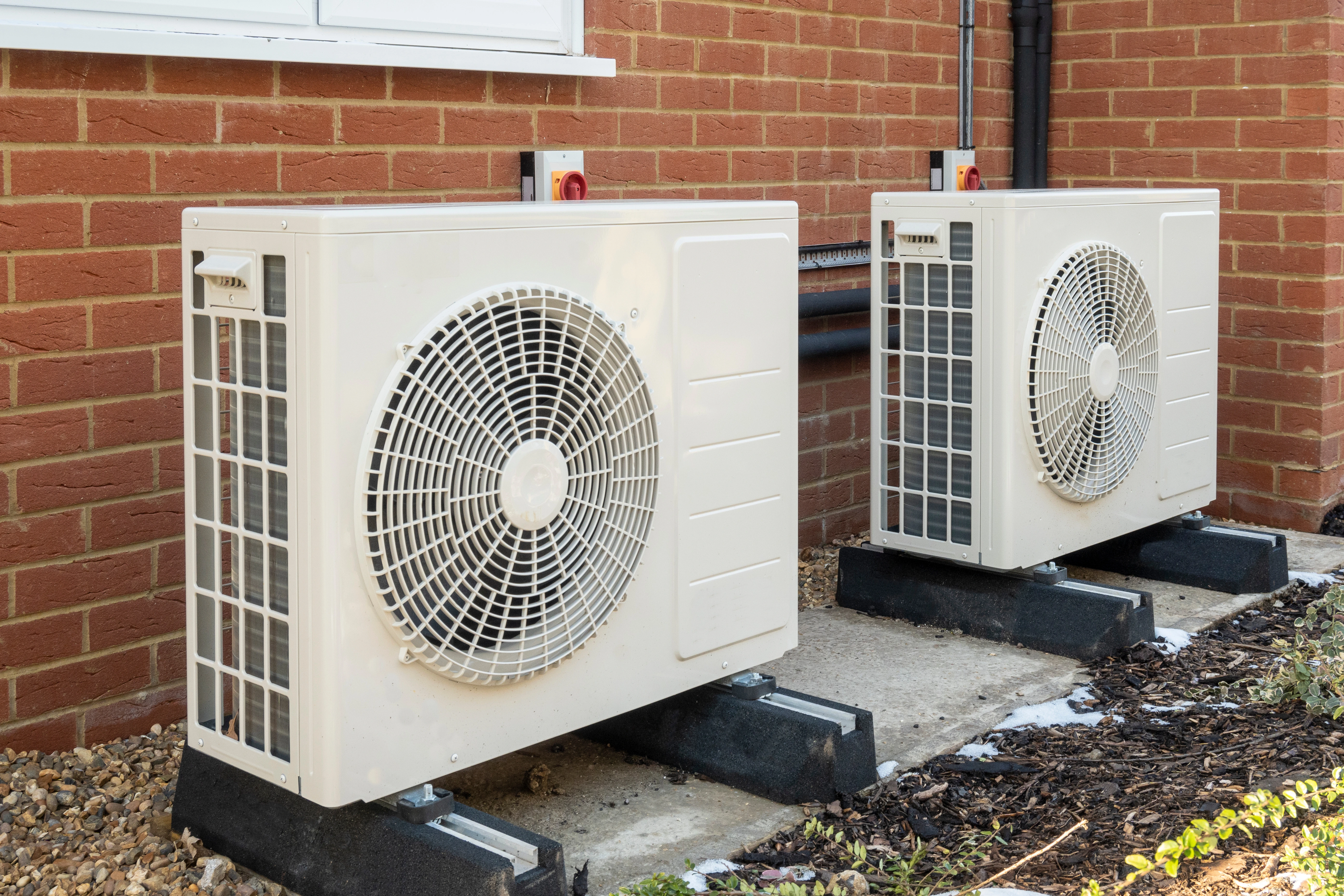 Image of air source heat pumps installed on the outside of a house