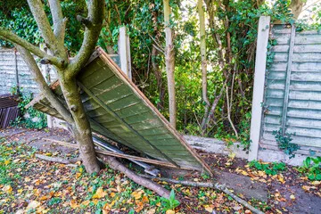 A fallen fence panel in a garden caused by sharp winds and storms. A fallen fence panel in a garden caused by sharp winds and storms.