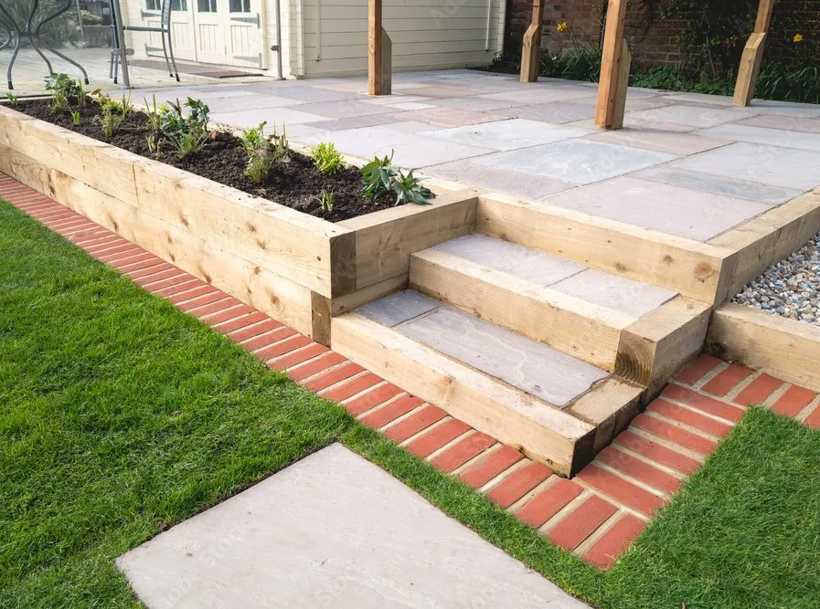 A simple image of some sleeper steps, furnished with some sleeper planters and some modern paving.