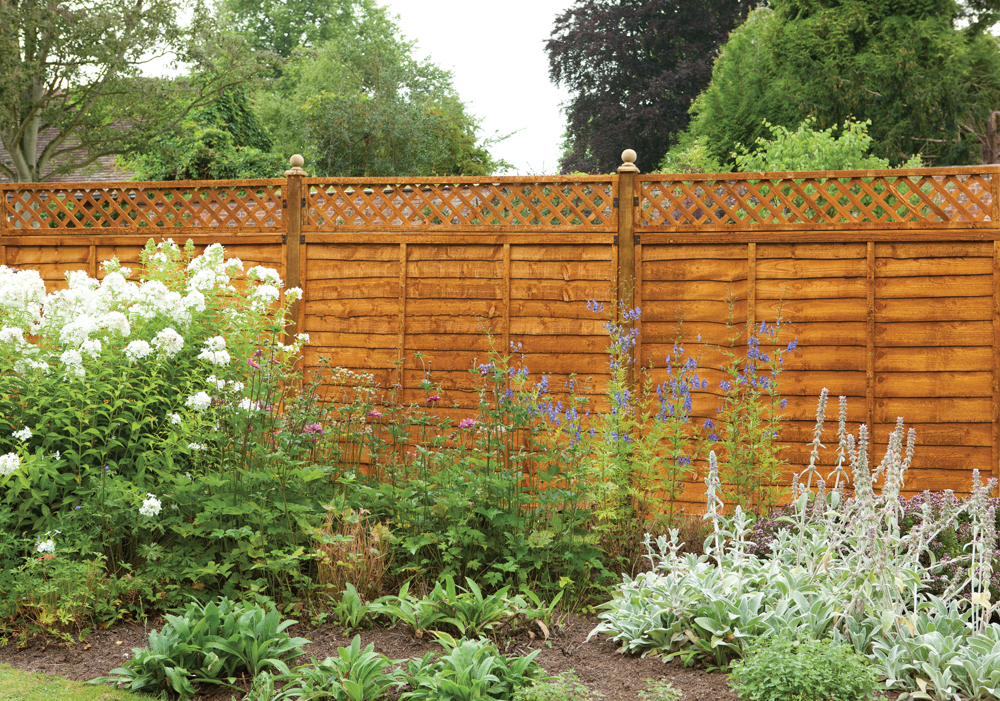 an image of a wooden timber fence with a wooden gate, and concrete posts. 