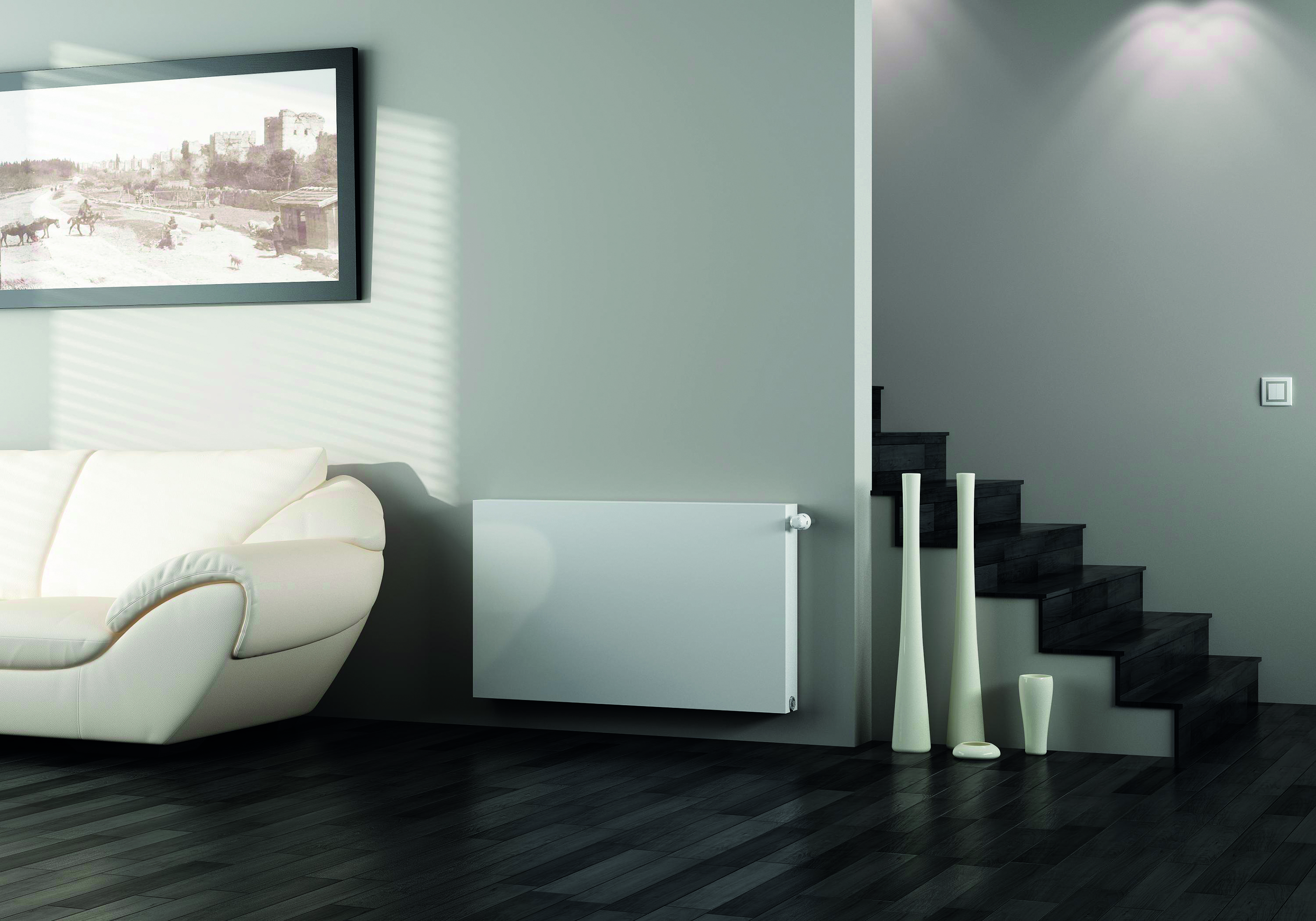 A white electric radiator hung against a bright, white wall. 
