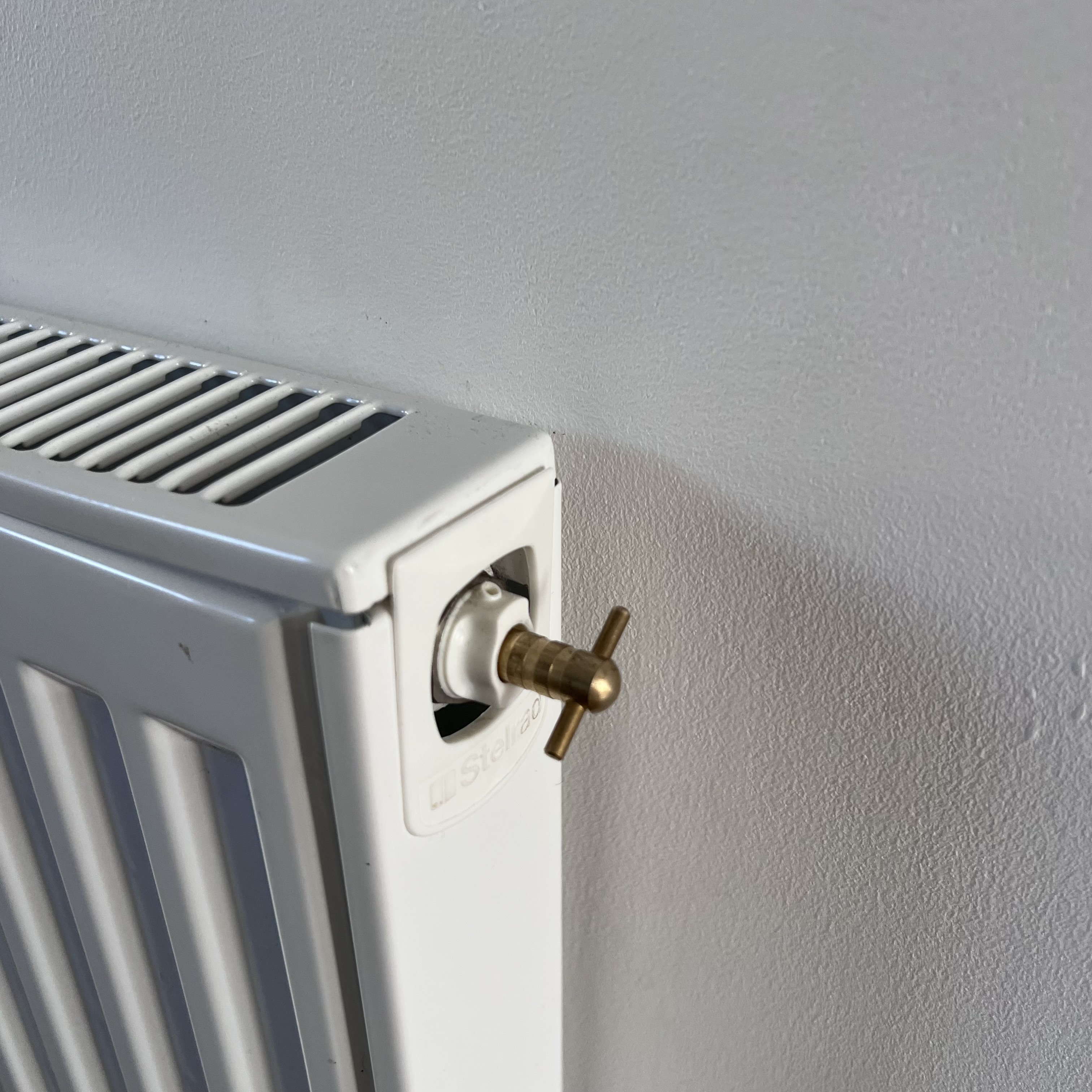 Radiator key placed on a radiator valve for adjustment. A tool needed for UK homes.
