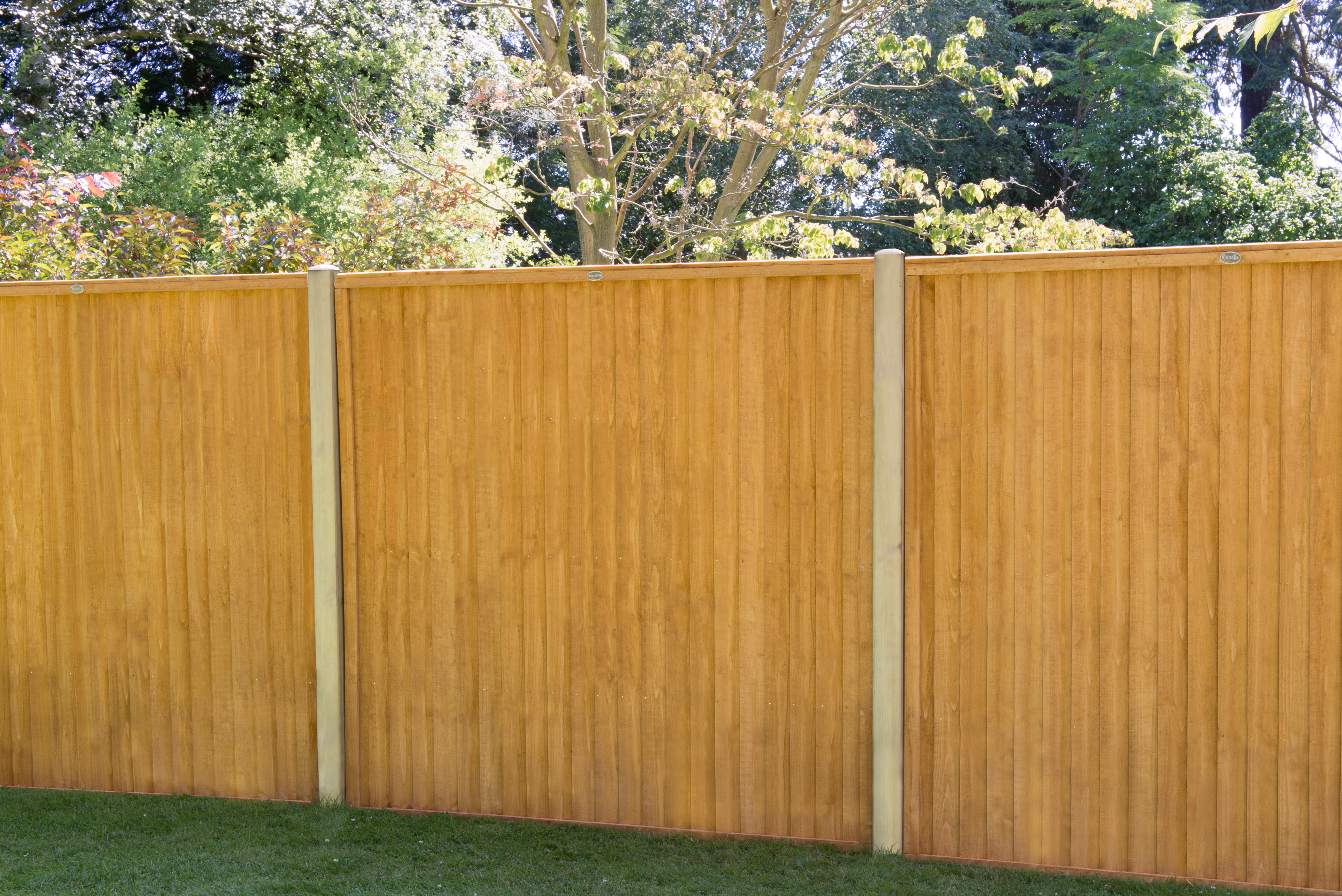 an image of a red and mahogany coloured fence amongst a red bricked house.