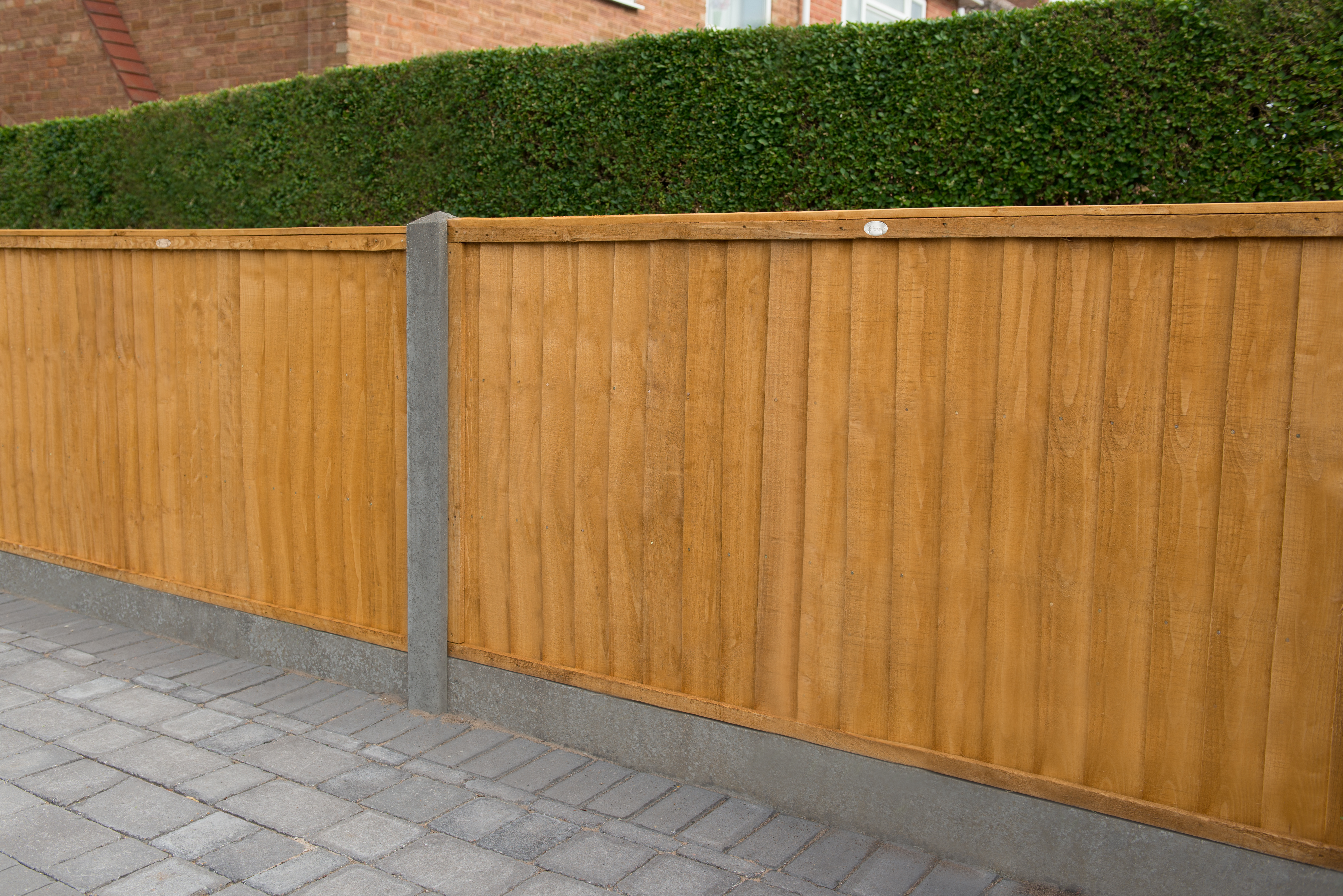 an image of a small wooden timber fence with small concrete posts and trim. 
