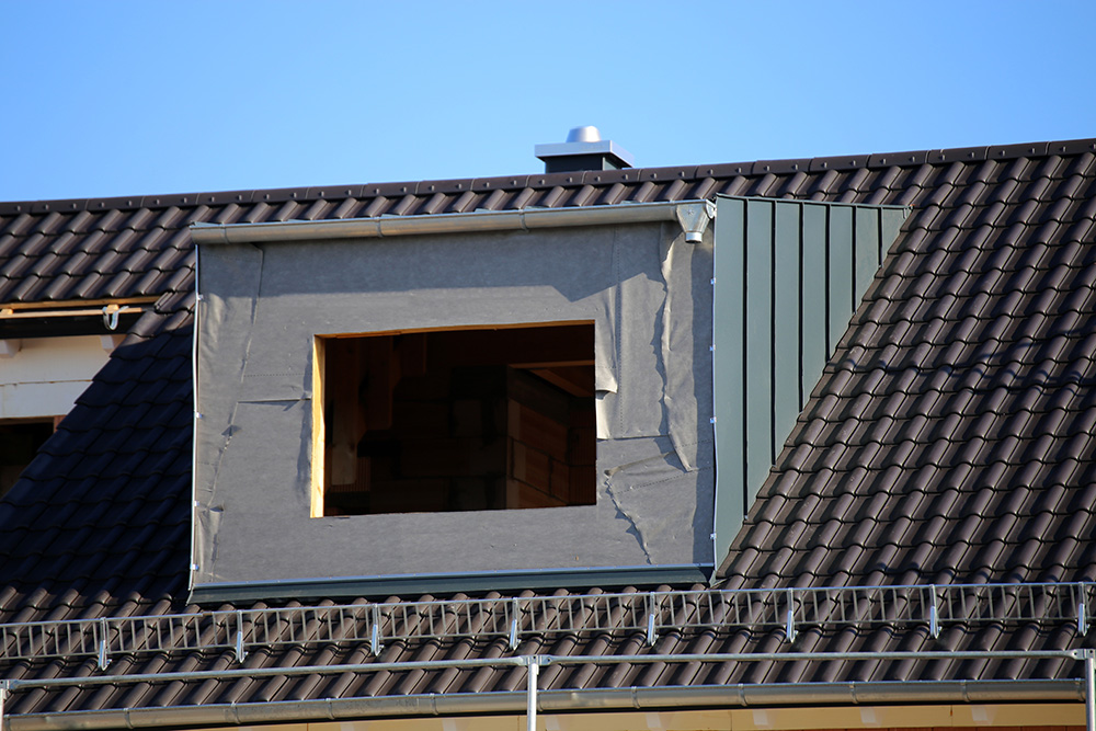 A loft conversion in progress inside someone's house, with loft joists inside. 