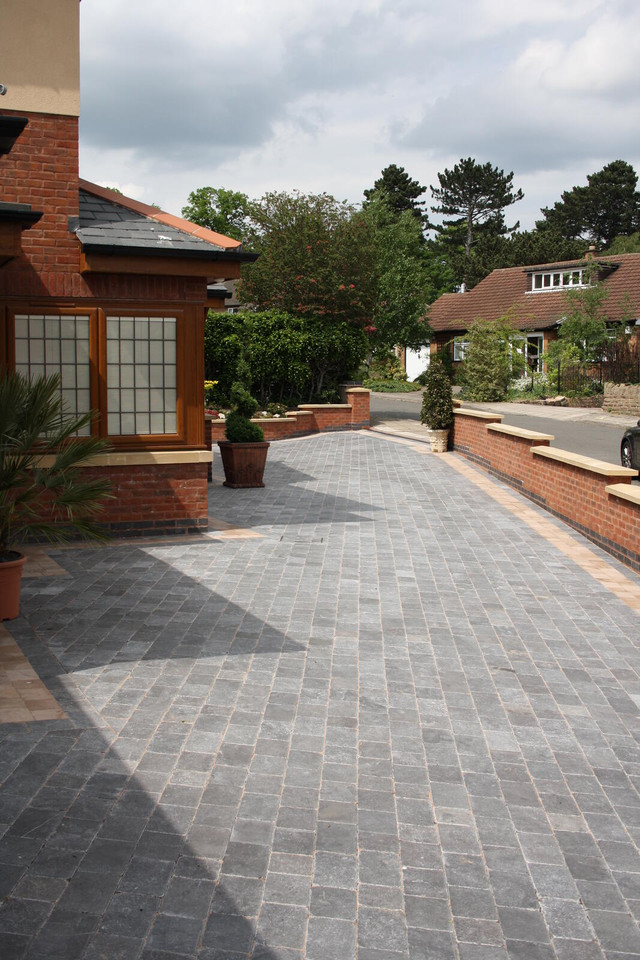 an image of a man jet washing the block paving to clean it