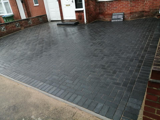 an image of block paving being laid and wheelbarrows 