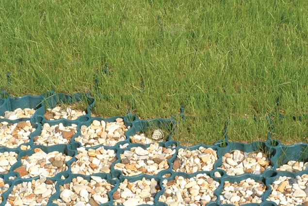 a close up image of some gravel underneath some garden netting.