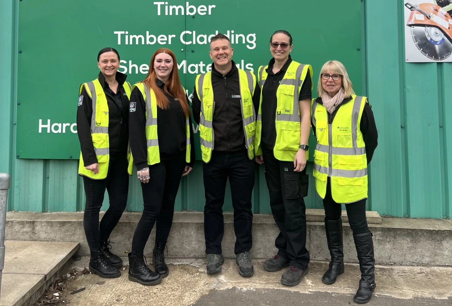 Four people pictured in front of the Howarth Timber logo sign, one of which being Ashley Rice, our new Assistant Branch Manager