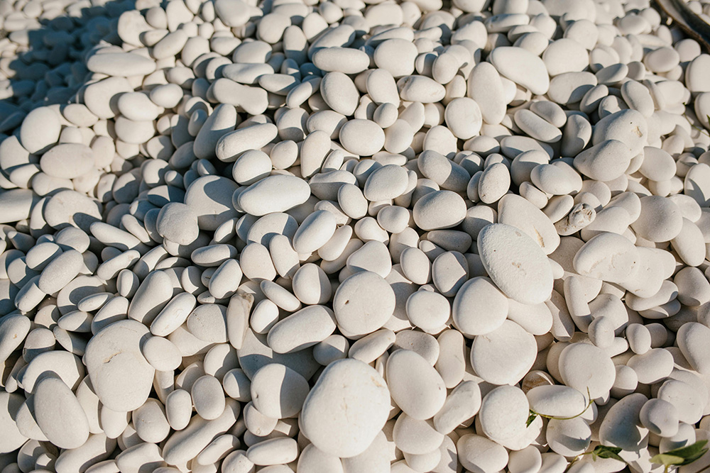 Large pebble stones arranged beautifully in a garden bed, adding texture and charm to outdoor landscaping.