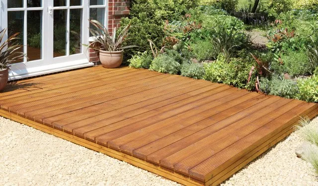 Image of some brown decking outside an external door leading to the garden.