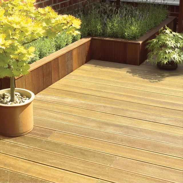 Composite decking outside in a garden, with plantpots around the edging.