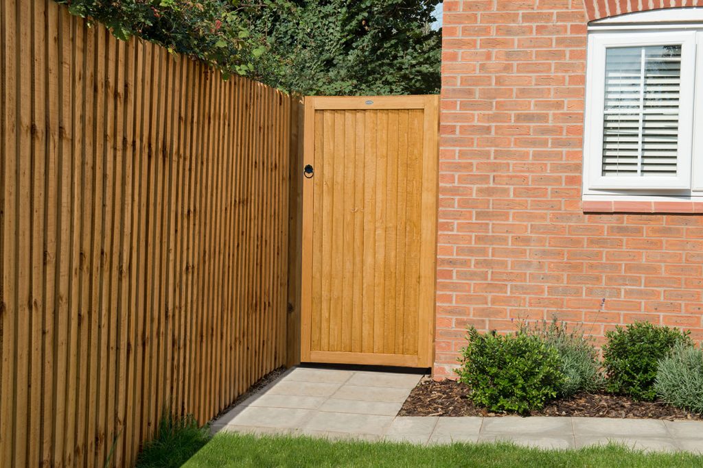 an image of a deep red, orange gate alongside a red brick home 