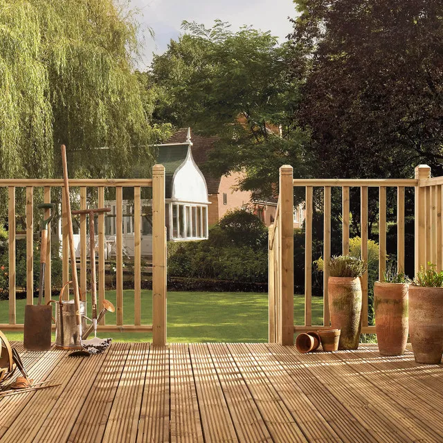 Image of some fencing posts leading down from decking to some grass in a garden.