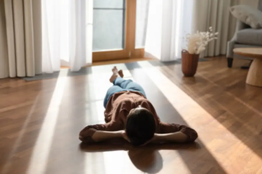 A woman laying on top of a floor with underfloor heating.