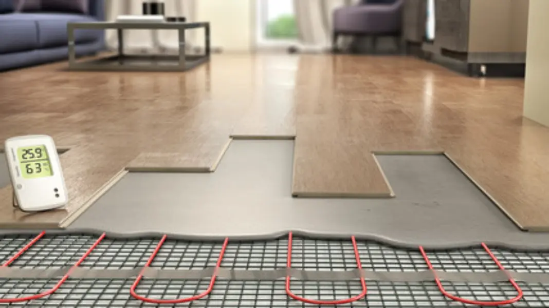 A close-up shot of flooring underneath some flooring, with a temperature meter placed next to it.