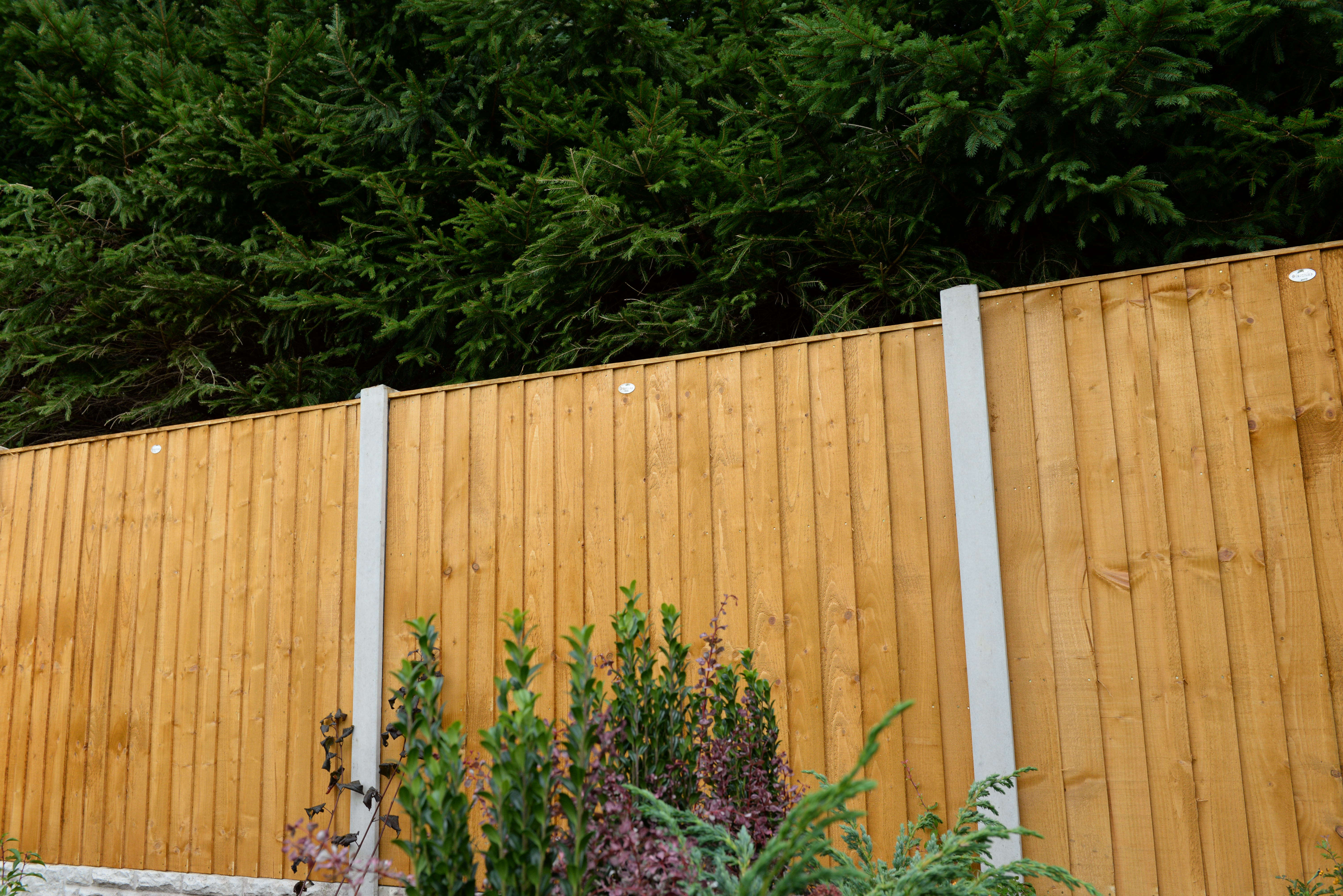 an image of a black and brown colour block fence amongst a red bricked wall.