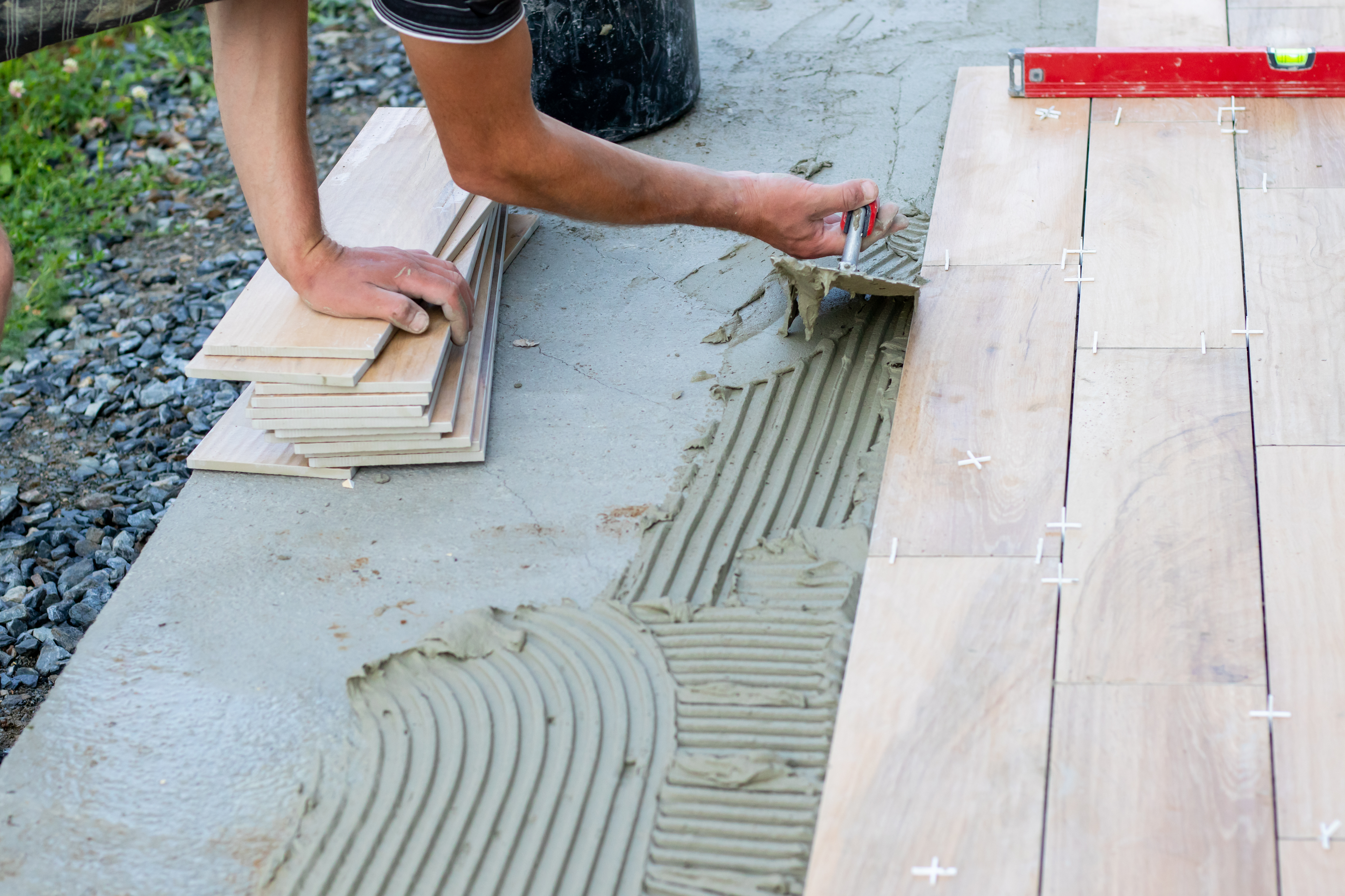 Cement being used to apply porcelain paving slabs to an outdoor area. 
