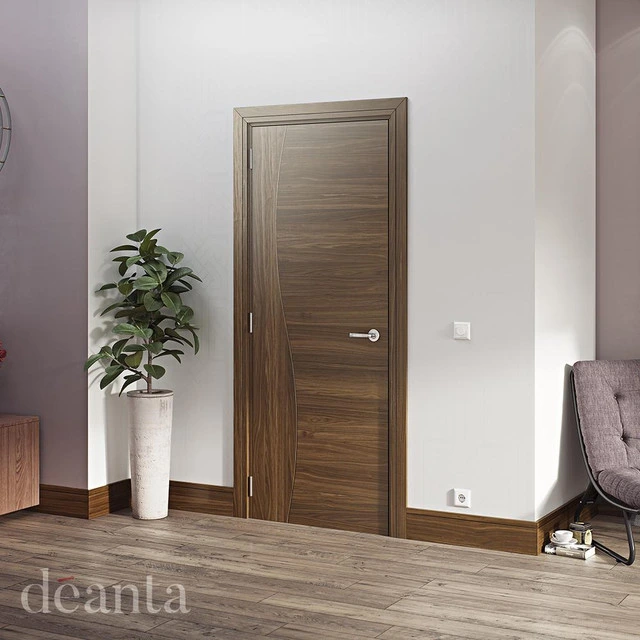 A dark brown, chestnut brown internal fire door in a modern, white room with a plant in the corner. A dark brown, chestnut brown internal fire door in a modern, white room with a plant in the corner.