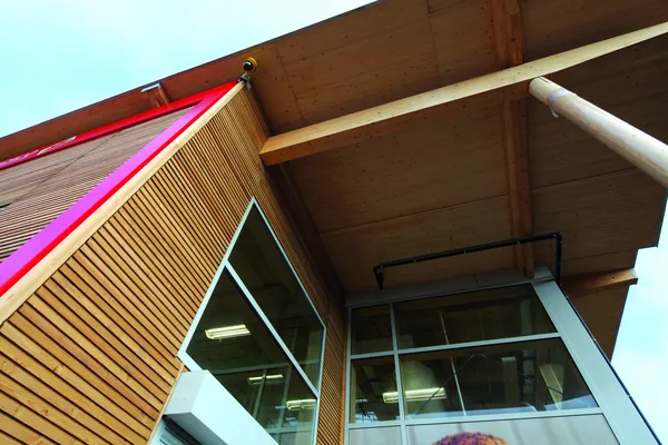 Cladding used with bright pink fittings and wide windows as part of a modernised building.