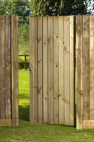 an image of a wooden gate surrounding by bushes