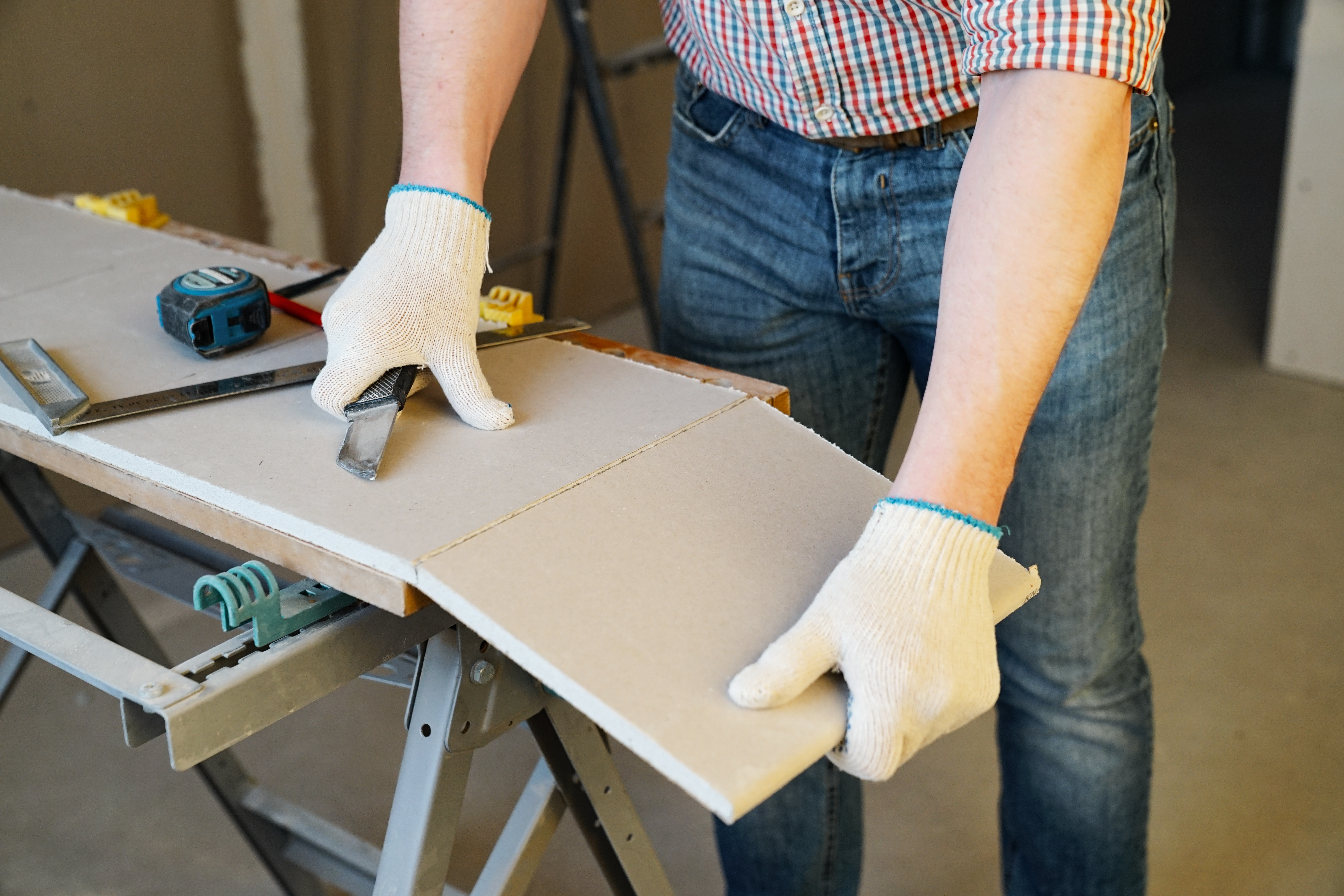 an image of a man cutting plasterboard