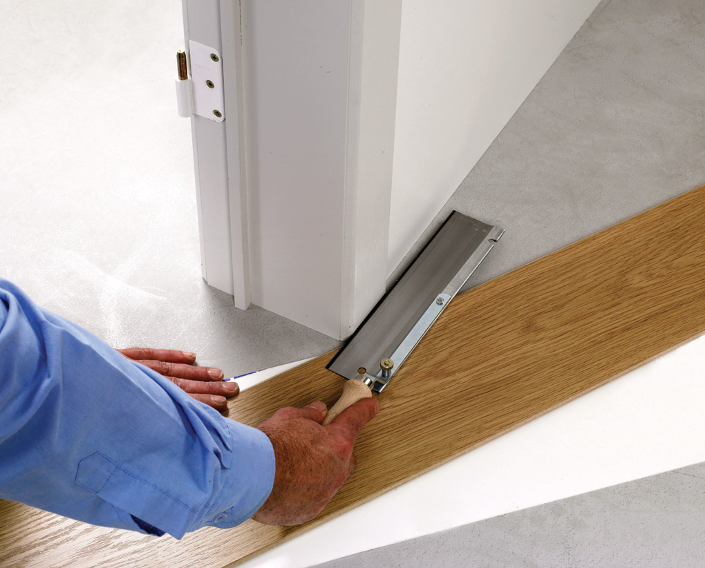 an image of a hallway with white walls and doors and laminate floors