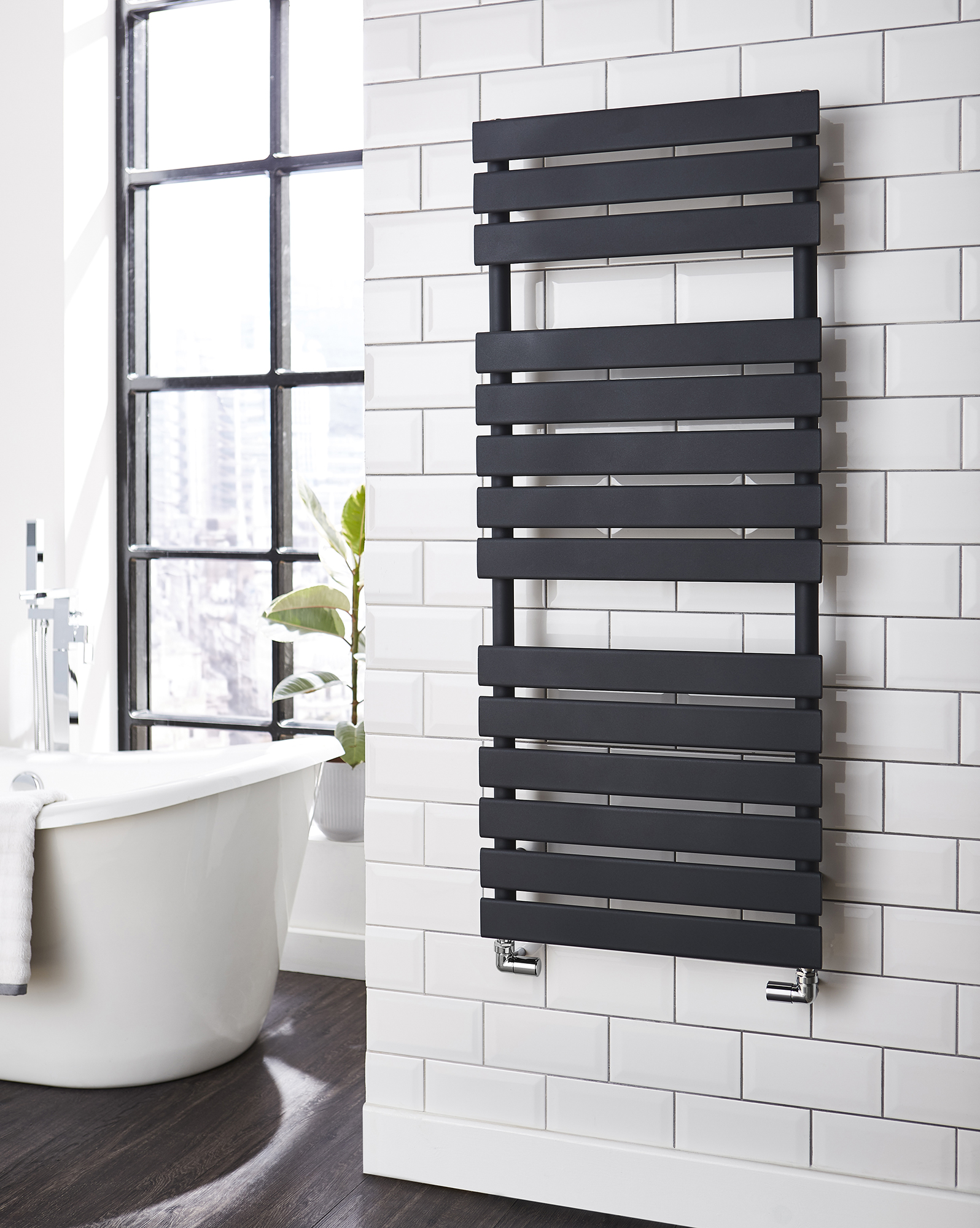 an image of a black ladder towel rail in a bathroom with a white bath. an image of a black ladder towel rail in a bathroom with a white bath.