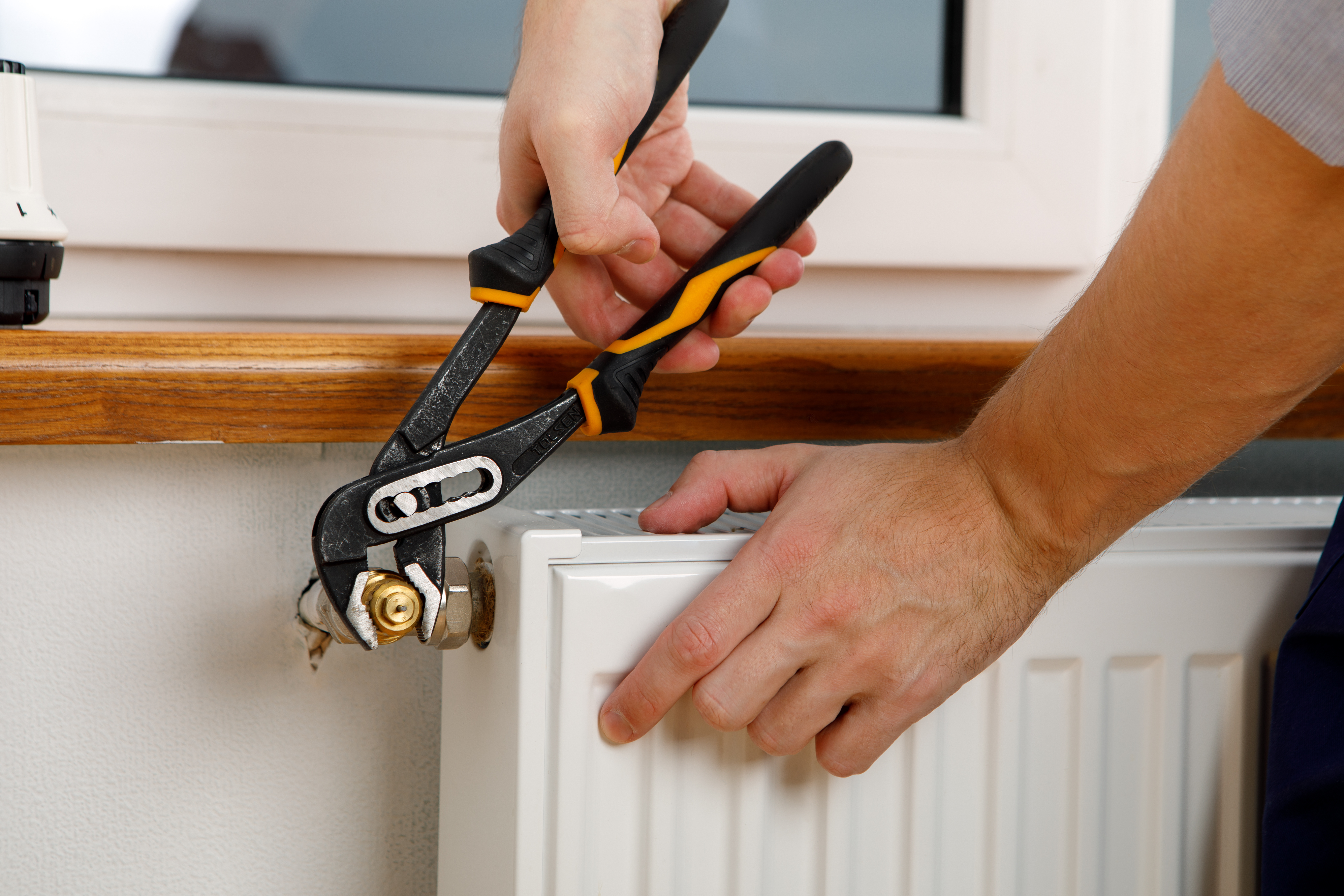 an image of a man using screwdriver to remove bleed valve an image of a man using screwdriver to remove bleed valve