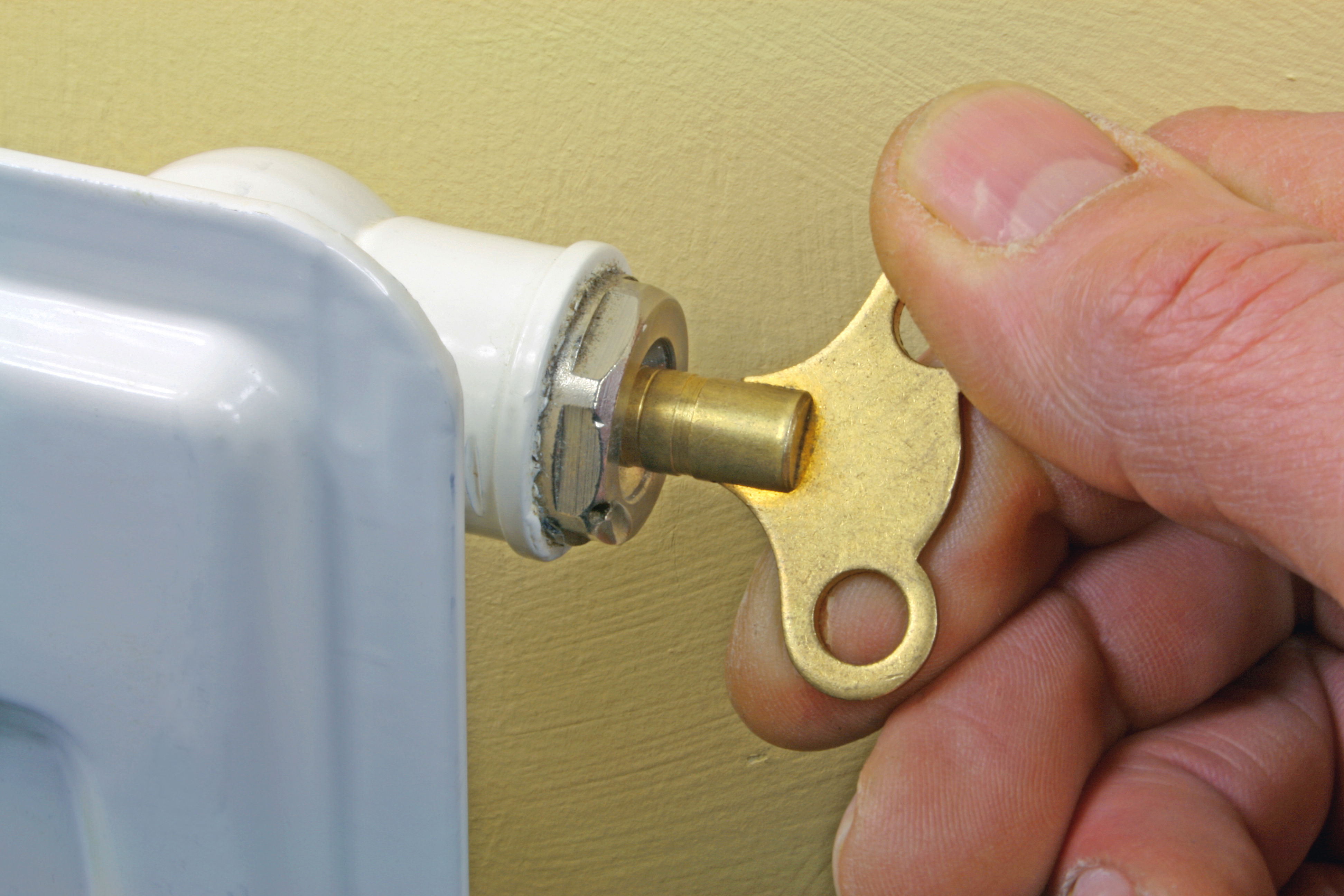 an image of a man using wrench to turn the water valve