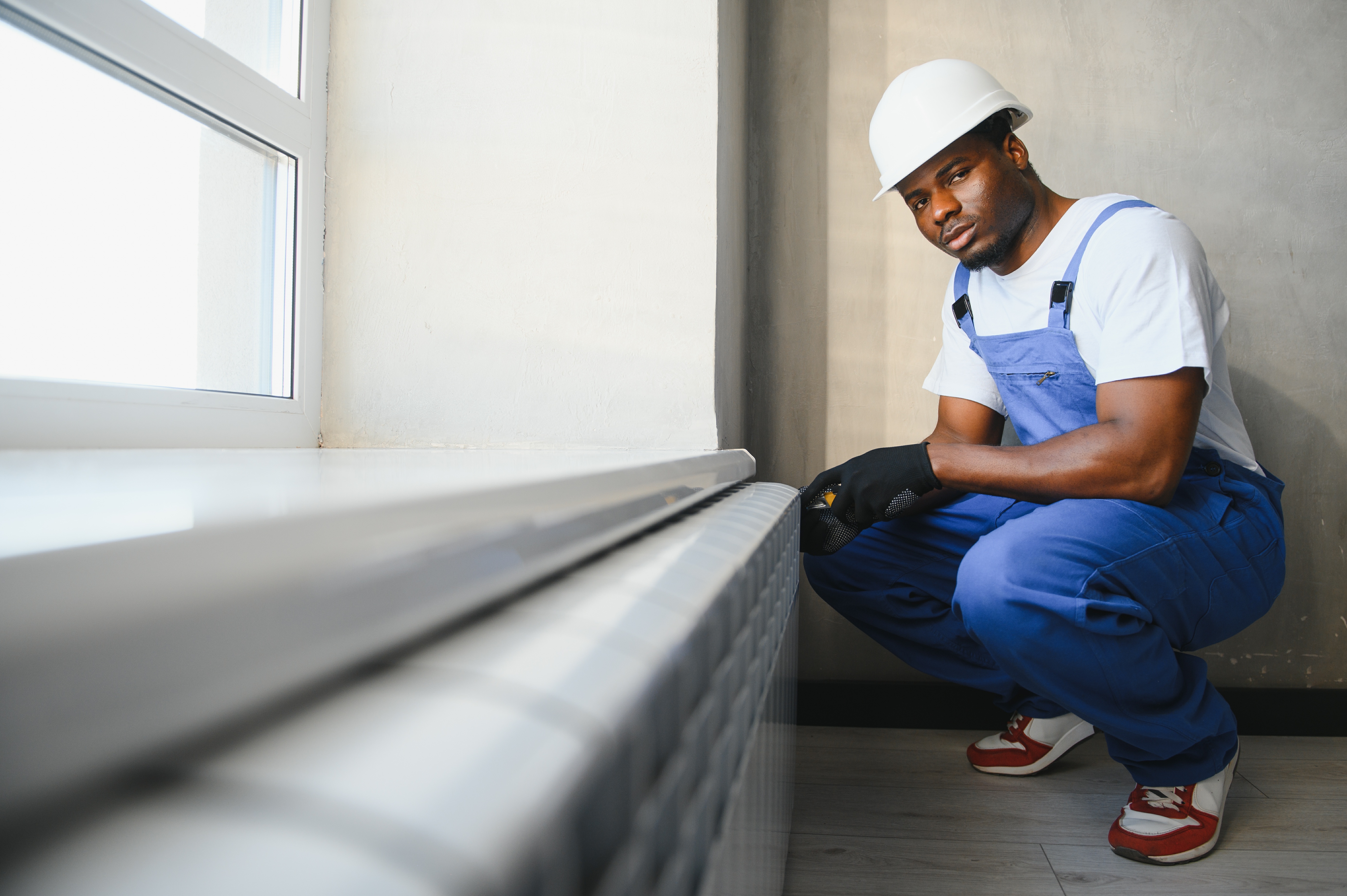 an image of a woman checking the radiator for cold spots with hands an image of a woman checking the radiator for cold spots with hands