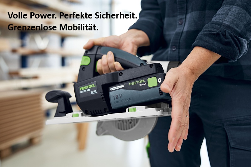 Nahaufnahme einer Person, die die Akku-Handkreissäge Festool HKC 55 K hält. Im Hintergrund ist eine Werkstatt erkennbar. Oben links steht der Slogan: 'Volle Power. Perfekte Sicherheit. Grenzenlose Mobilität.