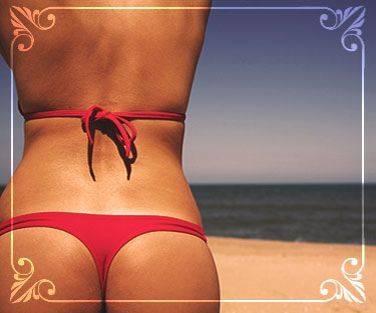 rear shot of a tanned woman in a red bikini on beach